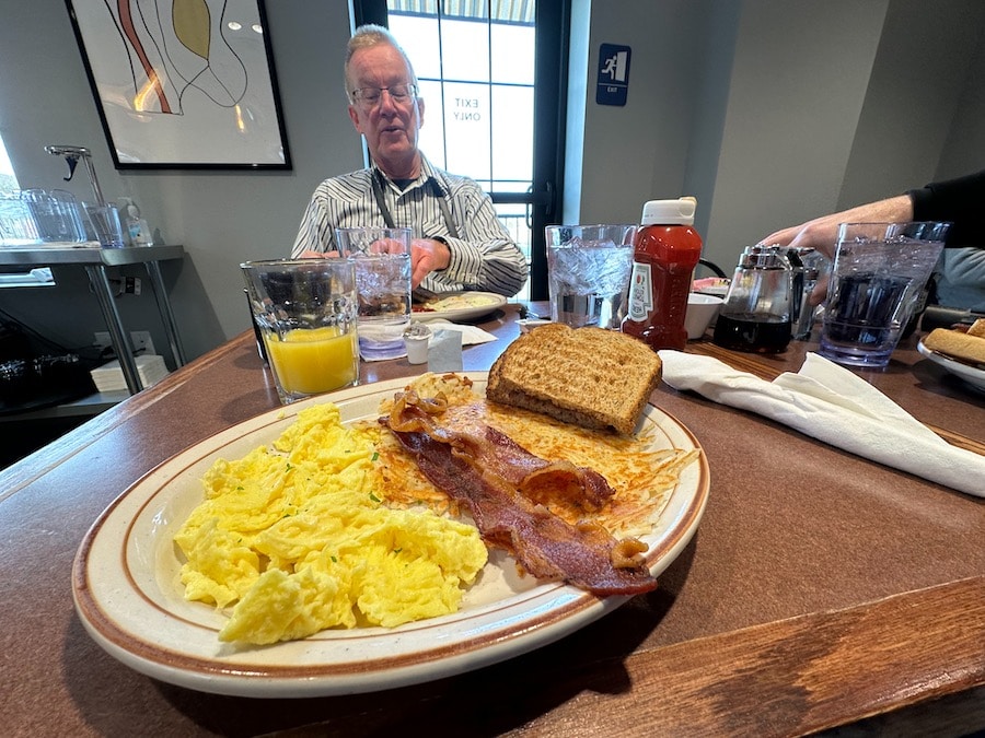 Scrambled eggs, bacon, and hash browns for breakfast.