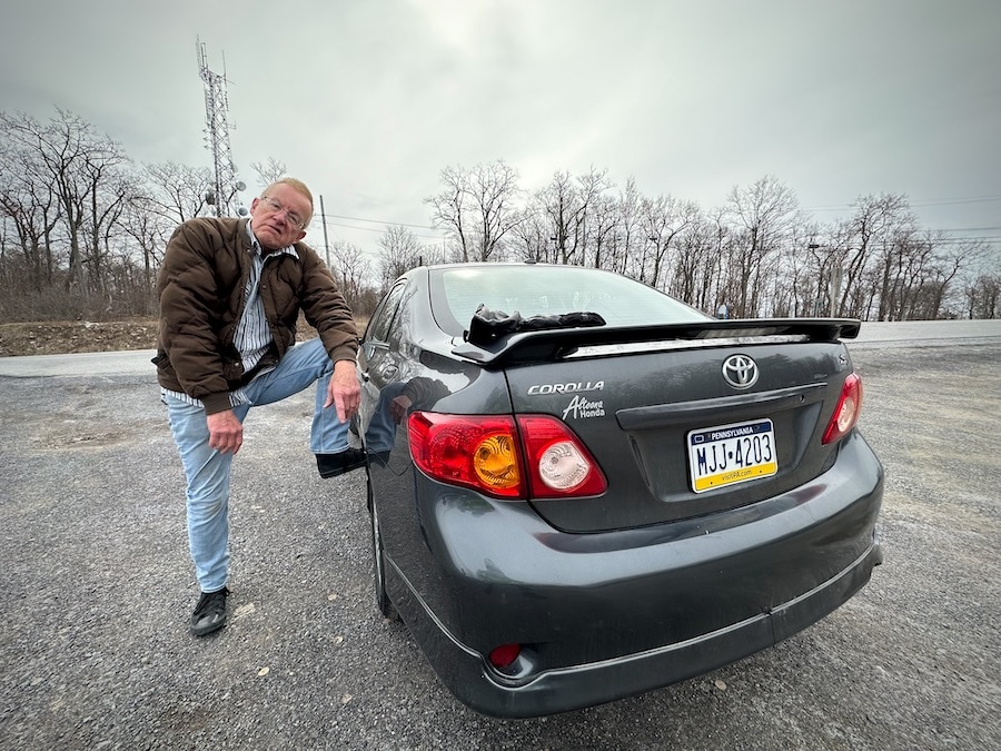 Paul Ruby with his foot on his car.