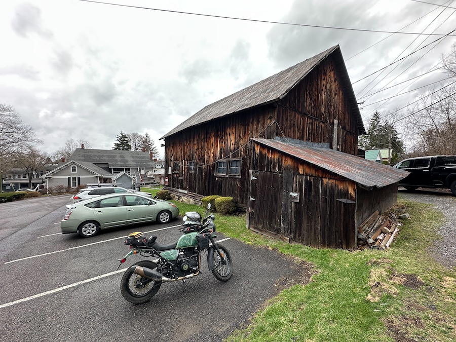 2022 Royal Enfield Himalayan motorcycle parked near an old barn.