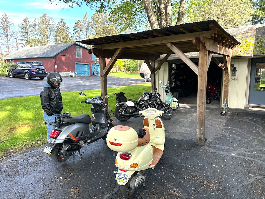 Vespa scooters gathered on a driveway.