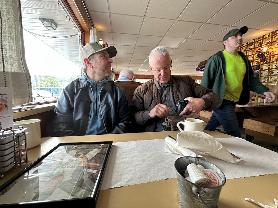 Two men sitting in a booth at a diner.