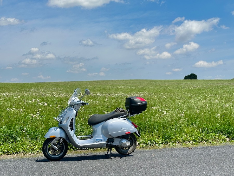 Vespa GTS 250 scooter along a rural road.