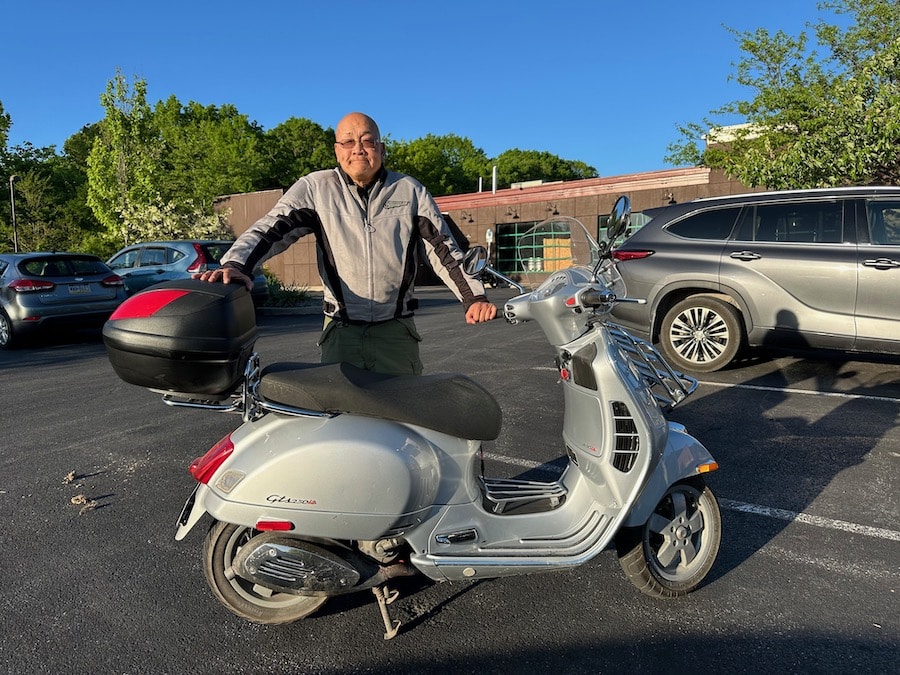 Dom Chang with a Vespa GTS 250 scooter.