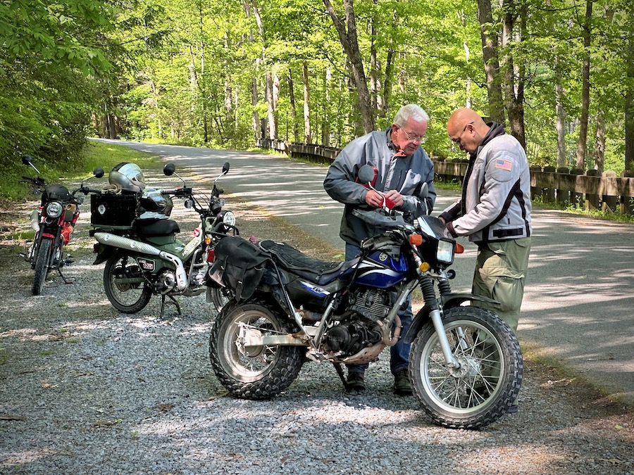 Two men looking at a motorcycle.