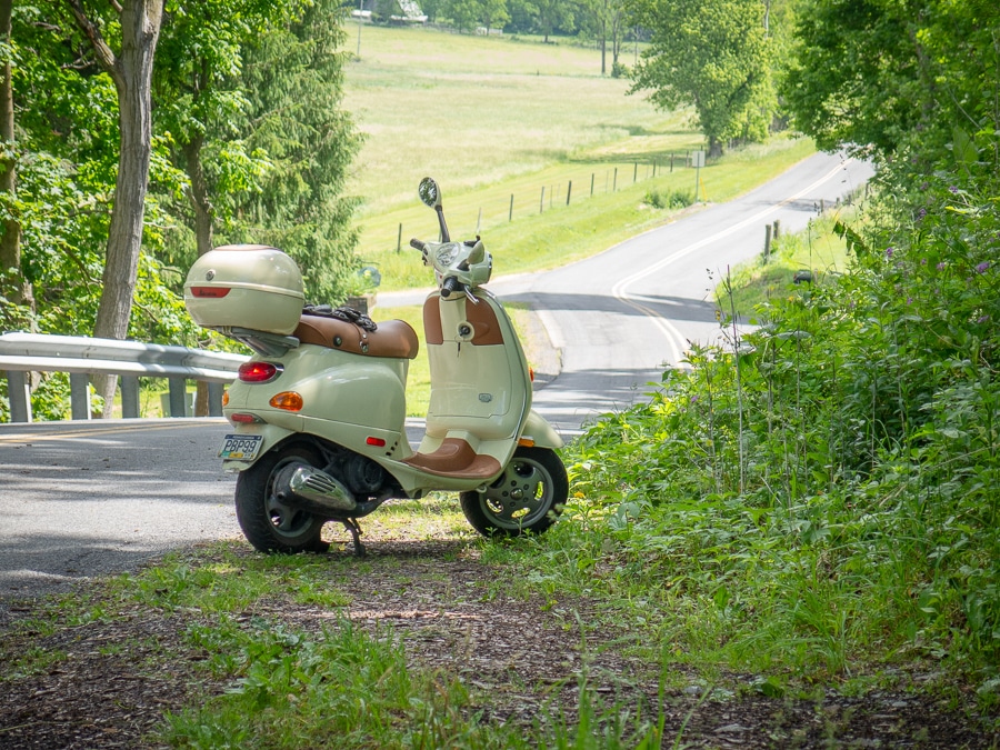 2004 Vespa ET4 scooter parked along a rural road.