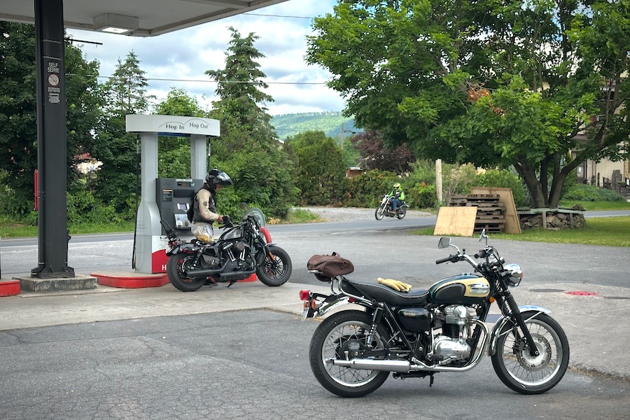 Motorcycles getting gas at a service station.