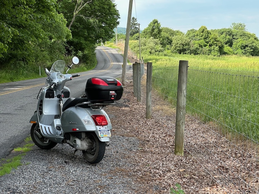 Vespa GTS scooter along a rural road.