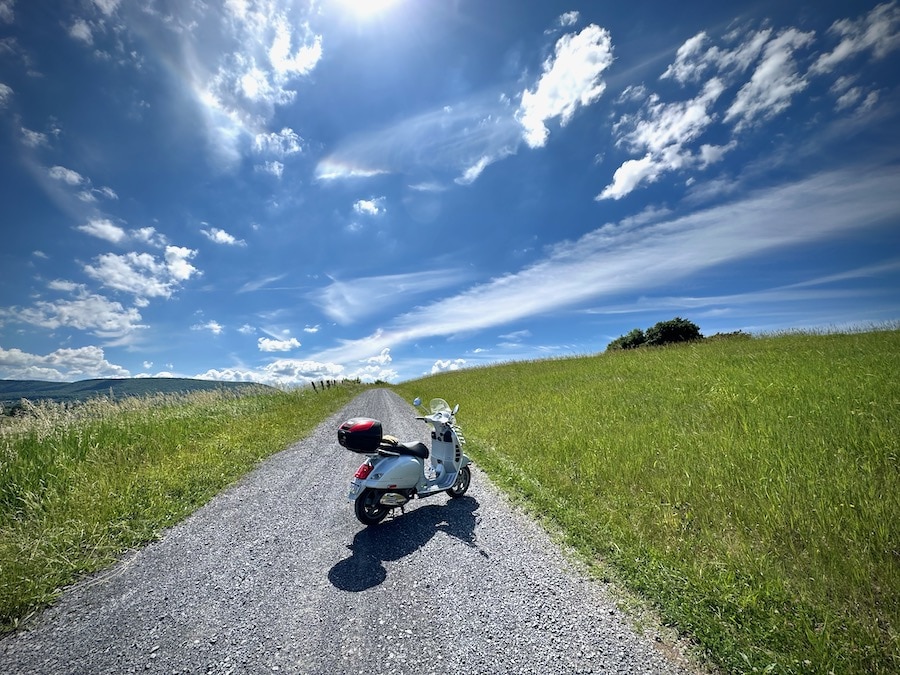 Vespa GTS 250 scooter on a farm lane.