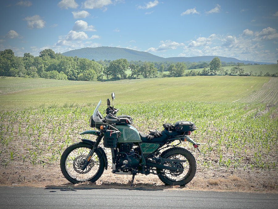 2022 Royal Enfield Himalayan motorcycle parked along a farm field.