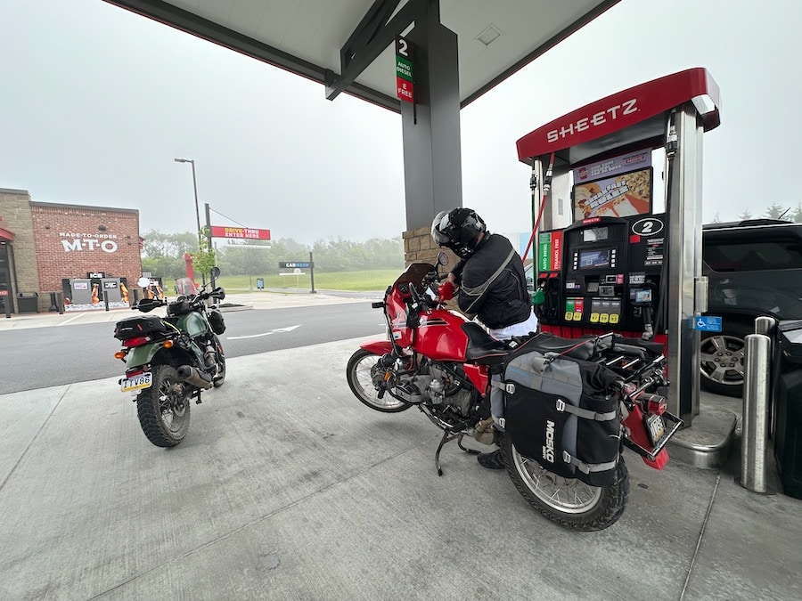 Two motorcycles at a convenience store for fuel.