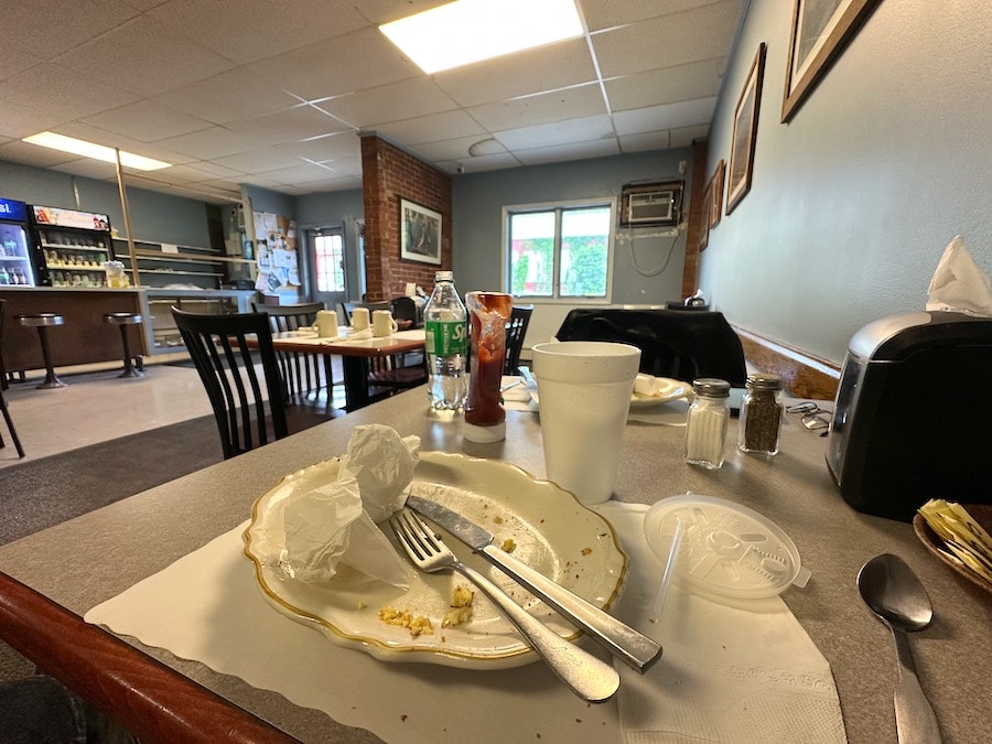 An empty breakfast plate in a small cafe.