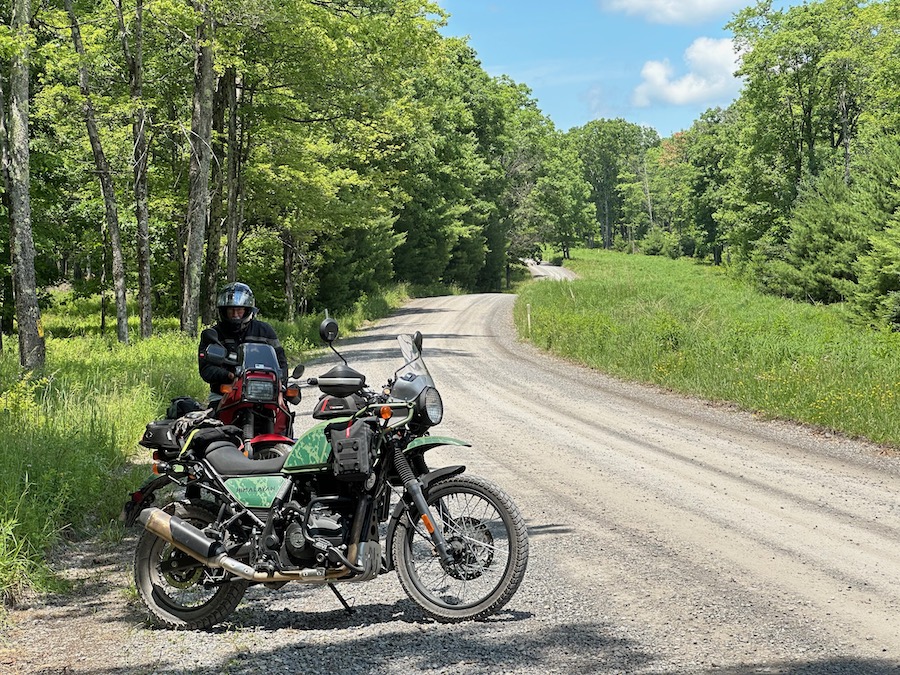 Motorcycles parked along a dirt road.