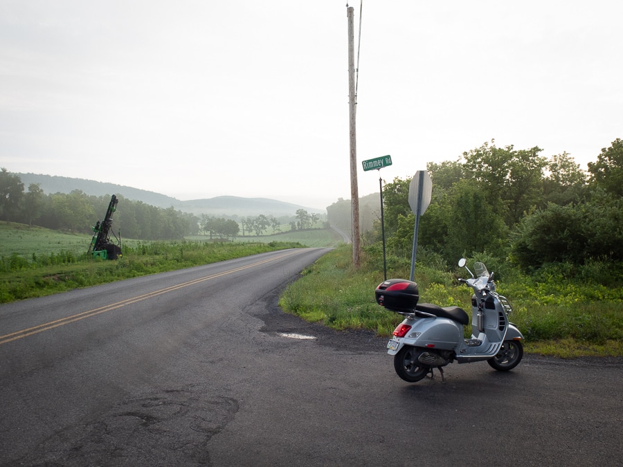 Vespa scooter and view of a rural road.