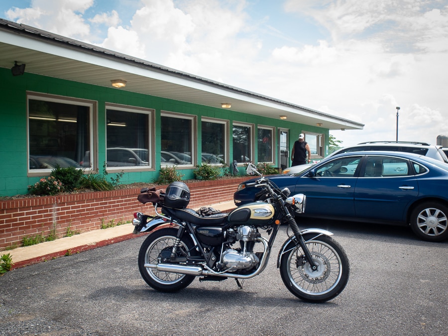 A 2001 Kawasaki W650 motorcycle parked outside the Green Acres Restaurant.