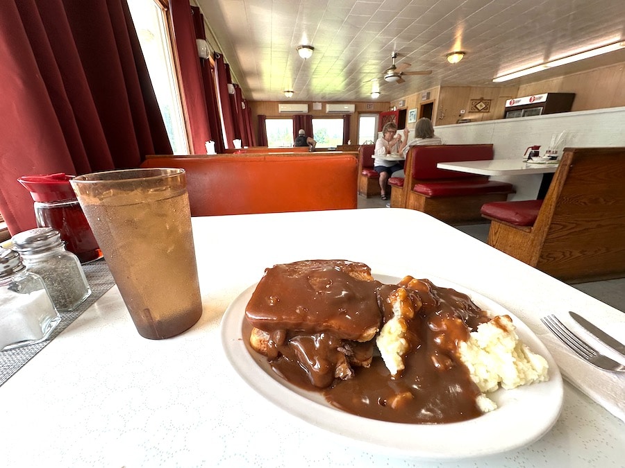 A plate with a hot roast beef sandwich with mashed potatoes and gravy.