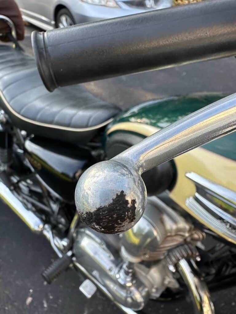 Asphalt on a motorcycle brake lever, evidence of a fall.