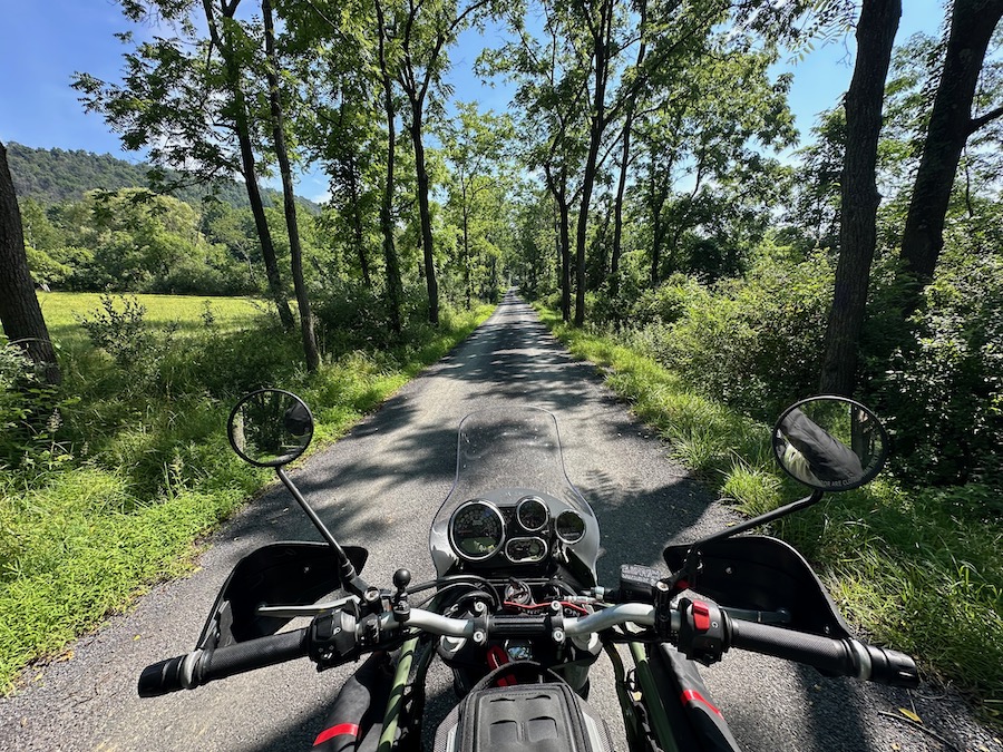 Looking across the instrument cluster of a Royal Enfield Himalayan motorcycle on a rural road.
