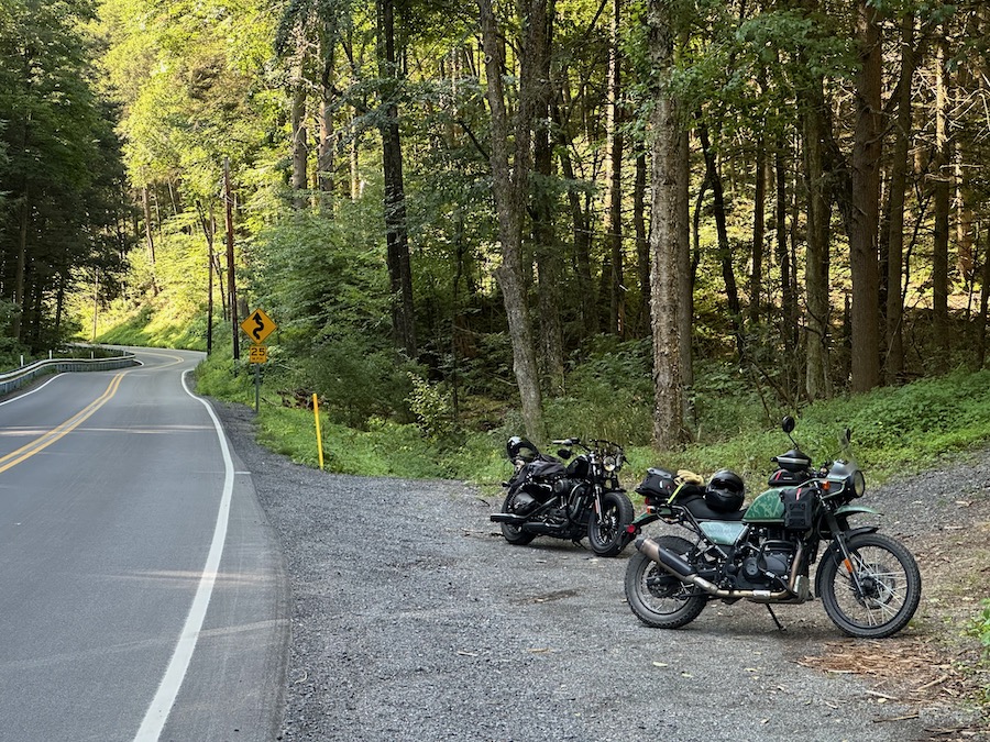 Two motorcycles parked along a road.