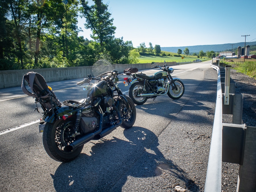 Two motorcycles parked along a rural road.