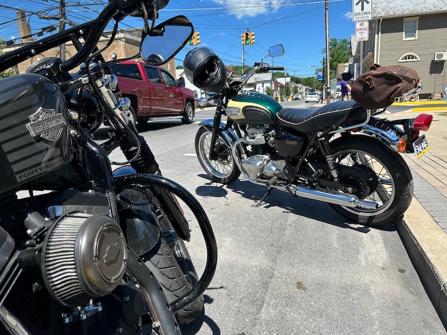 Two motorcycles parked along a town street.