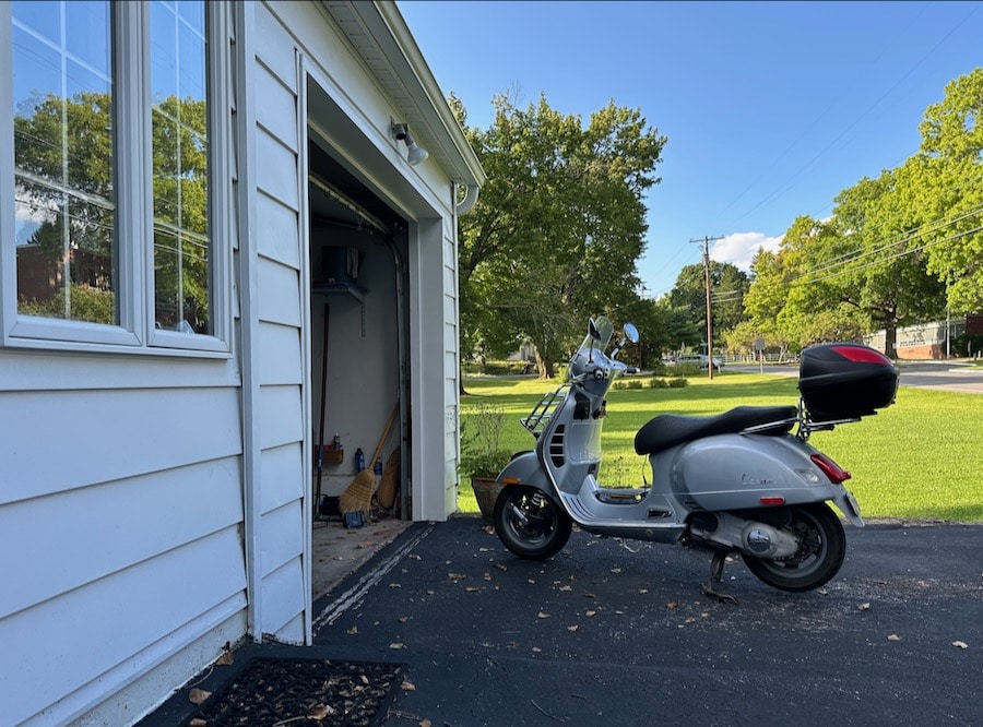A Vespa GTS 250 scooter parked in a driveway.