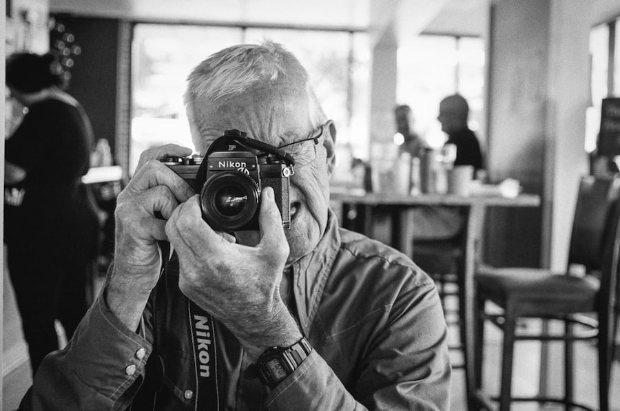 Portrait of Paul Ruby using his Nikon F camera.