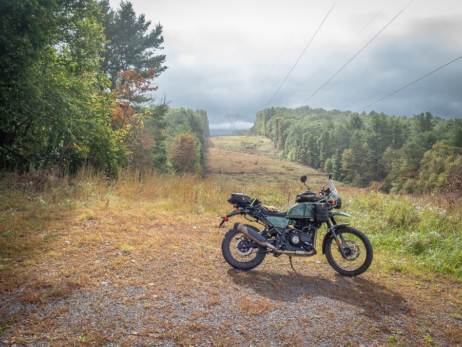 A Royal Enfield Himalayan parked at a power line cut.