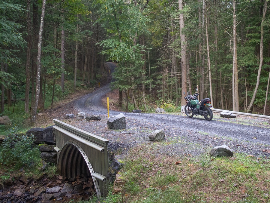 A Royal Enfield Himalayan motorcycle deep in the woods.