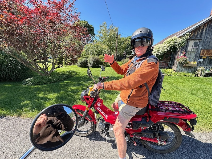 Paul Ruby on his red Honda Trail 125 motorcycle.