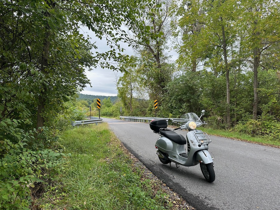 A Vespa GTS 250 scooter on a rural road.
