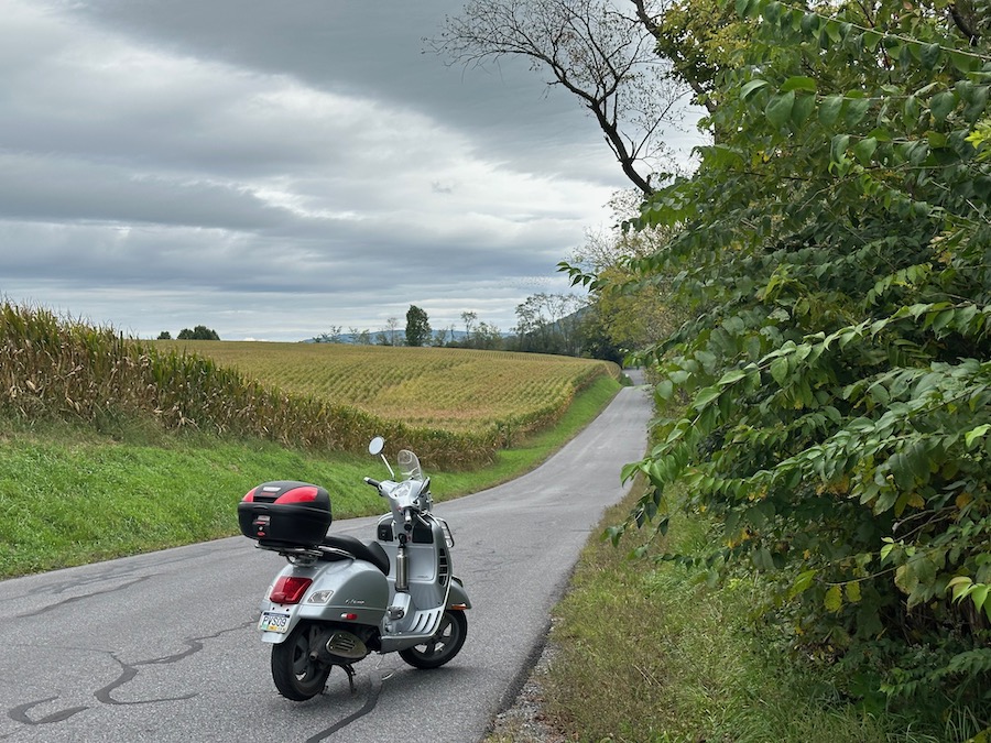 A Vespa GTS scooter on a rural road.
