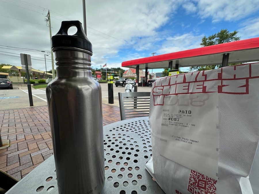 A stop to sit outside and have breakfast with a Vespa scooter parked nearby.