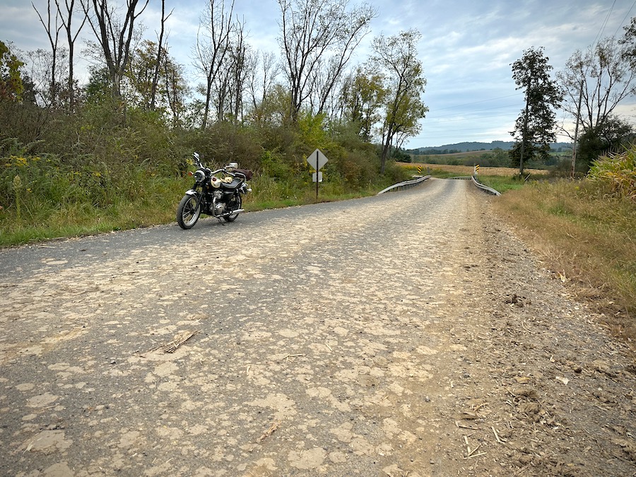 Road dotted with mud fallen from vehicles harvesting corn.
