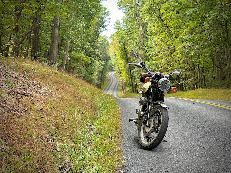 A 2001 Kawasaki W650 parked on a quiet rural road.
