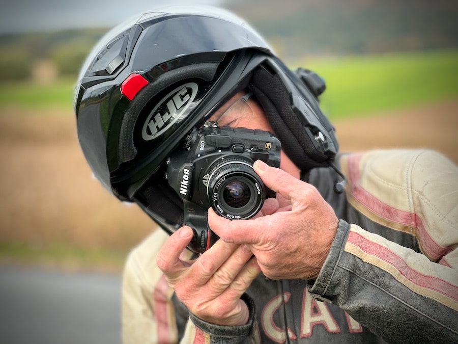 Man wearing a motorcycle helmet taking a picture.