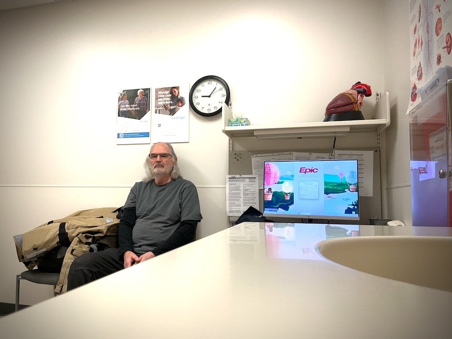 Man waiting in a doctor's office exam room.
